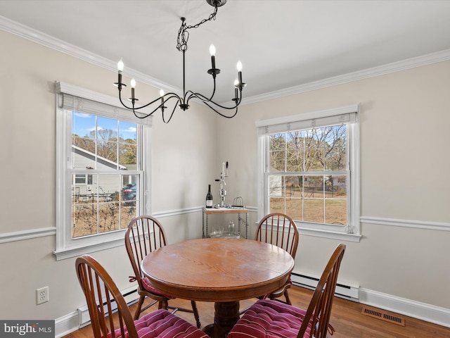 dining area featuring visible vents, crown molding, baseboards, and wood finished floors