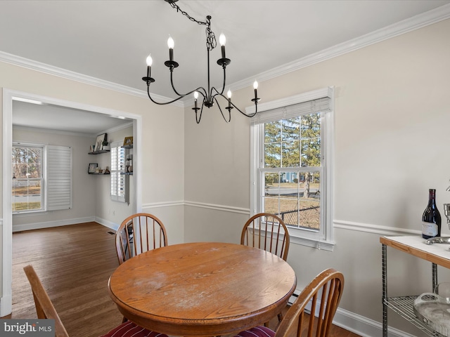 dining area featuring crown molding, a healthy amount of sunlight, wood finished floors, and a chandelier