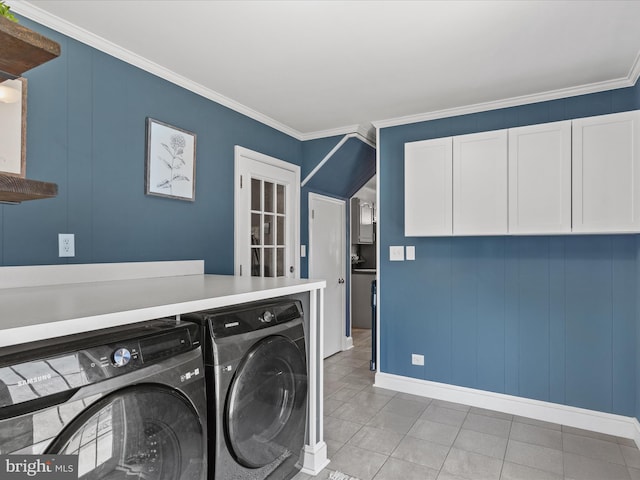 laundry area with light tile patterned floors, baseboards, cabinet space, ornamental molding, and washing machine and dryer