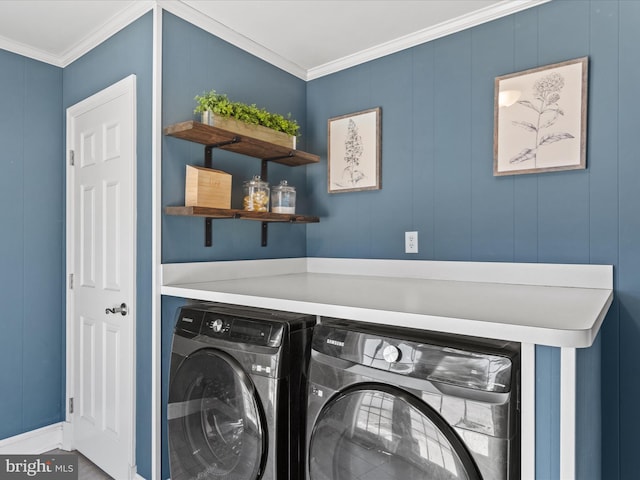 laundry room featuring laundry area, ornamental molding, and washer and clothes dryer