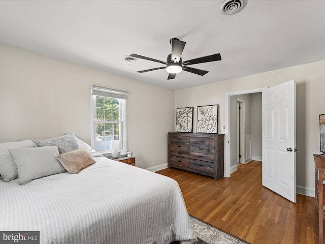 bedroom with visible vents, baseboards, and wood finished floors