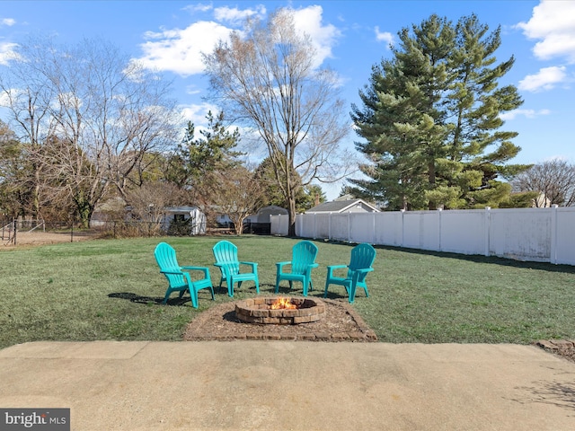 view of patio / terrace with an outbuilding, a fire pit, and a fenced backyard