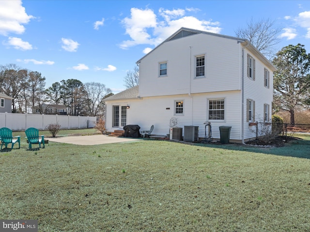 rear view of property featuring a patio area, central air condition unit, a lawn, and a fenced backyard