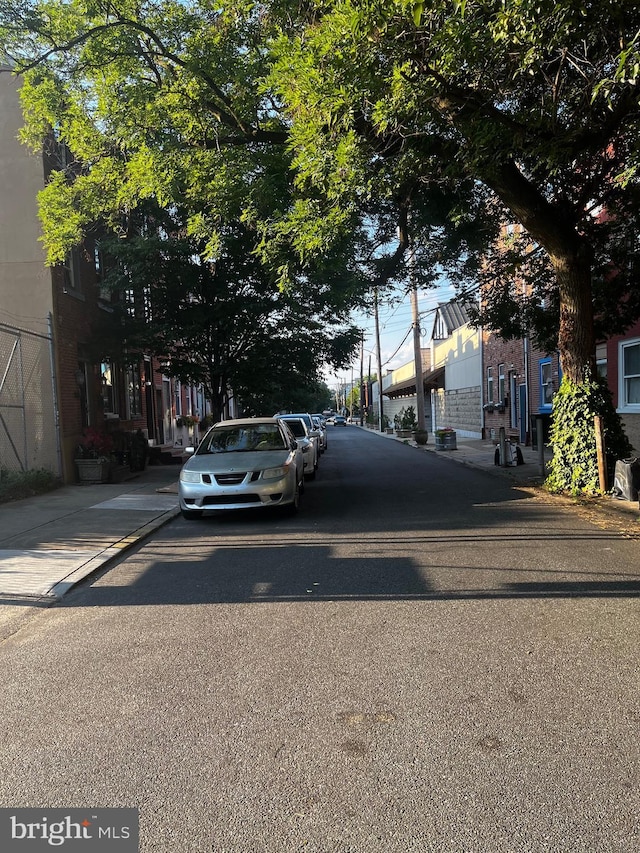 view of road with a residential view, curbs, and sidewalks