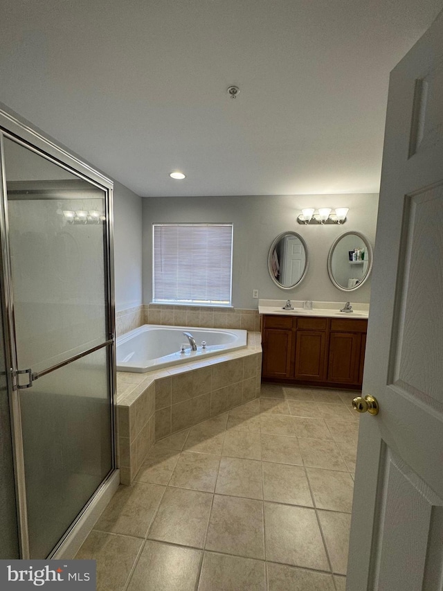 bathroom with a shower stall, tile patterned floors, double vanity, a bath, and a sink