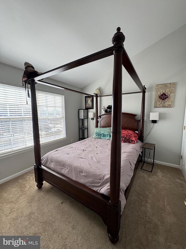 carpeted bedroom featuring vaulted ceiling and baseboards