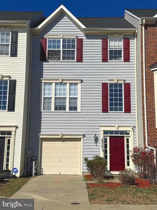 townhome / multi-family property with concrete driveway and a garage