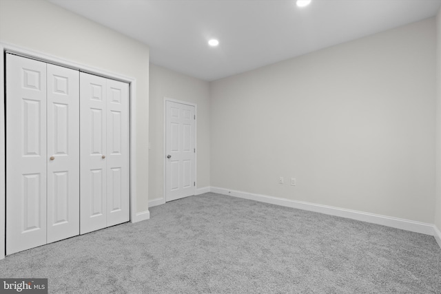 unfurnished bedroom featuring carpet, baseboards, a closet, and recessed lighting