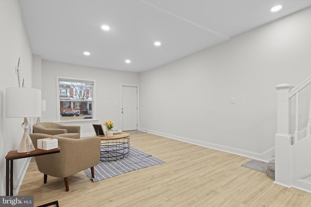 sitting room with stairway, recessed lighting, wood finished floors, and baseboards