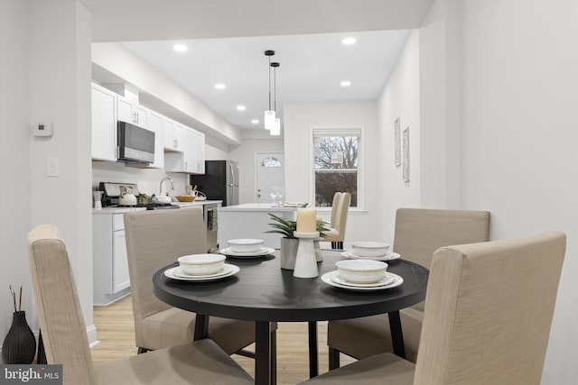 dining room with light wood-type flooring and recessed lighting