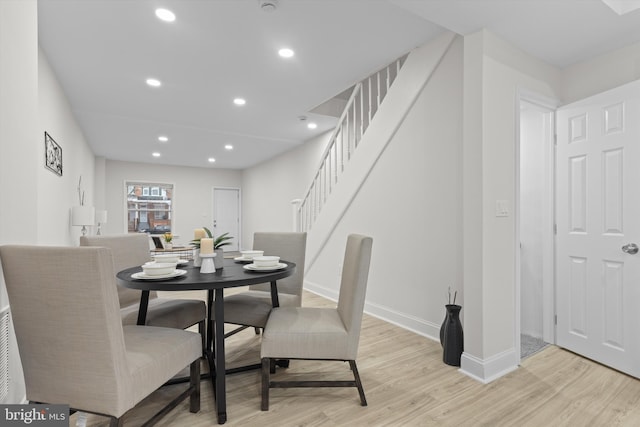 dining area featuring recessed lighting, light wood finished floors, and stairs