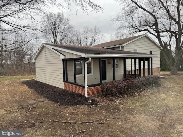 view of front of property featuring brick siding and a shingled roof