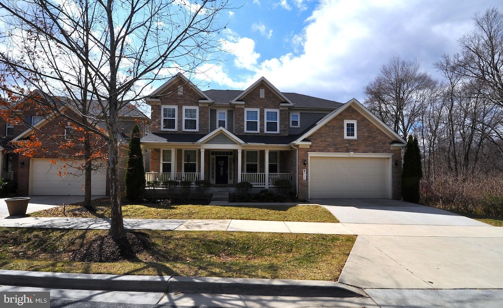 craftsman-style house with covered porch, driveway, and brick siding