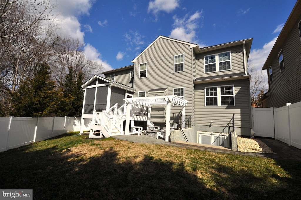 back of property featuring a sunroom, a fenced backyard, a yard, and a pergola