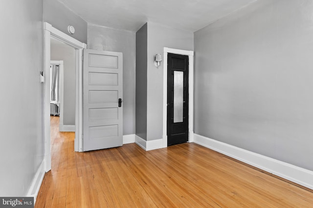 unfurnished bedroom featuring light wood-style flooring and baseboards