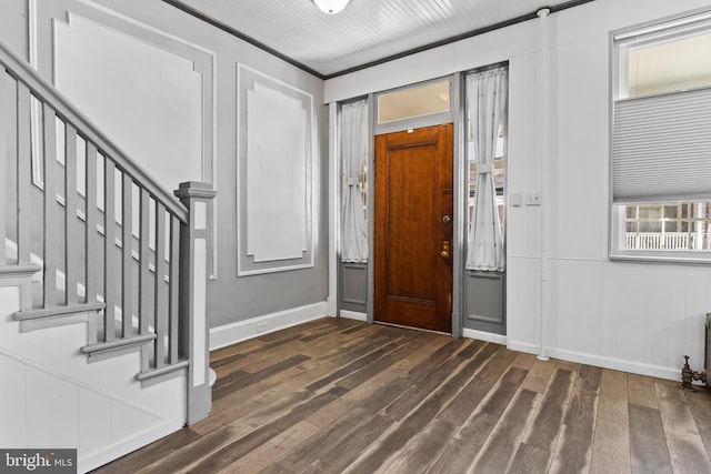 foyer entrance featuring dark wood-style flooring, baseboards, and stairs