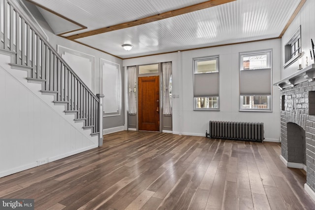 entryway with dark wood-style flooring, a fireplace, baseboards, stairway, and radiator heating unit