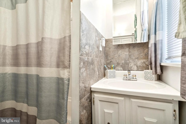 full bathroom featuring curtained shower, tile walls, and vanity