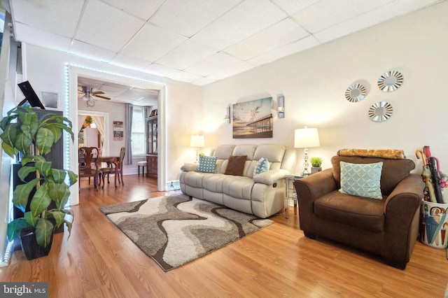 living area featuring a paneled ceiling and wood finished floors