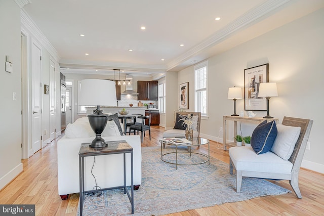 living room featuring crown molding, recessed lighting, baseboards, and light wood finished floors