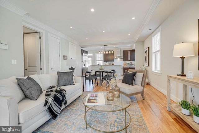 living room with crown molding, recessed lighting, baseboards, and light wood-type flooring