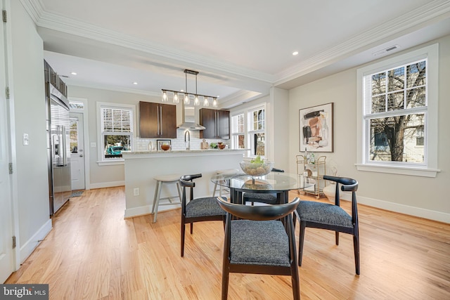 dining space featuring light wood finished floors, visible vents, and a wealth of natural light