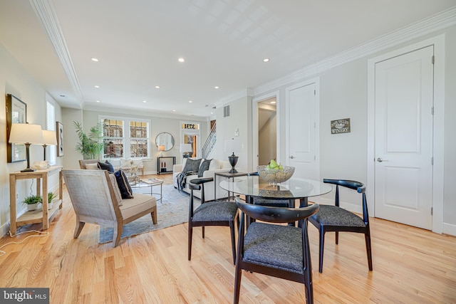 dining space featuring light wood finished floors, recessed lighting, and crown molding