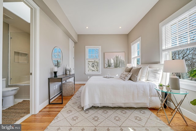 bedroom with recessed lighting, light wood-style flooring, ensuite bath, and baseboards