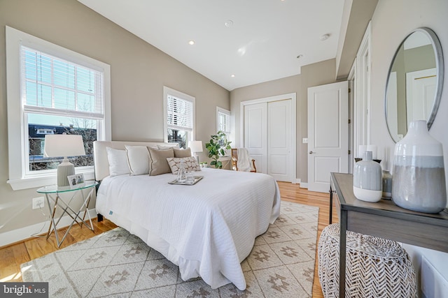 bedroom featuring recessed lighting, a closet, baseboards, and light wood-style flooring