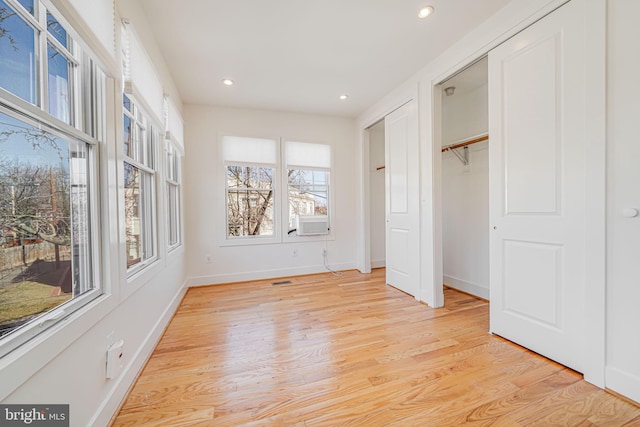 unfurnished bedroom featuring recessed lighting, light wood-style flooring, cooling unit, and baseboards