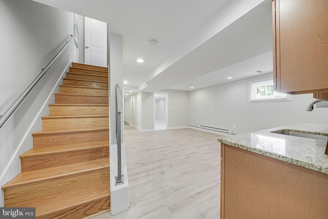 stairway with recessed lighting, baseboards, baseboard heating, and wood finished floors