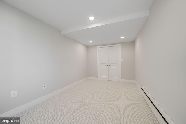 spare room featuring recessed lighting, light colored carpet, a baseboard heating unit, and baseboards