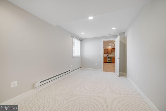 spare room with recessed lighting, light colored carpet, baseboards, and baseboard heating