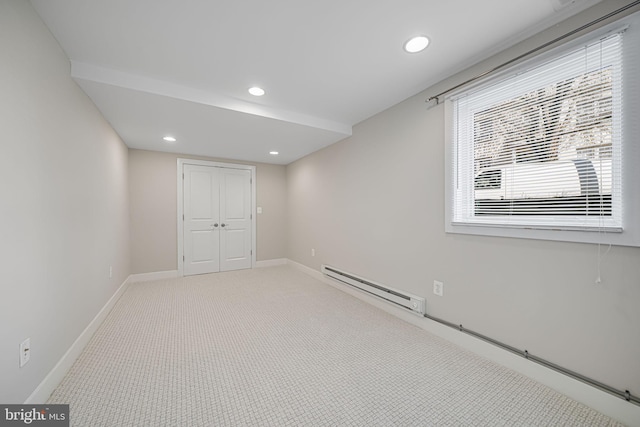 empty room featuring recessed lighting, a baseboard heating unit, baseboards, and light carpet