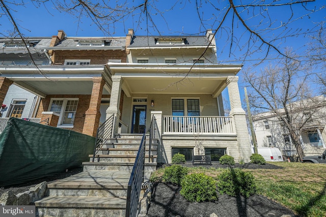 view of front of house featuring stairs, a porch, mansard roof, and brick siding