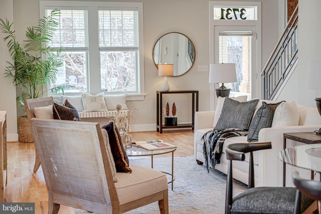 living room with light wood finished floors, stairway, and baseboards