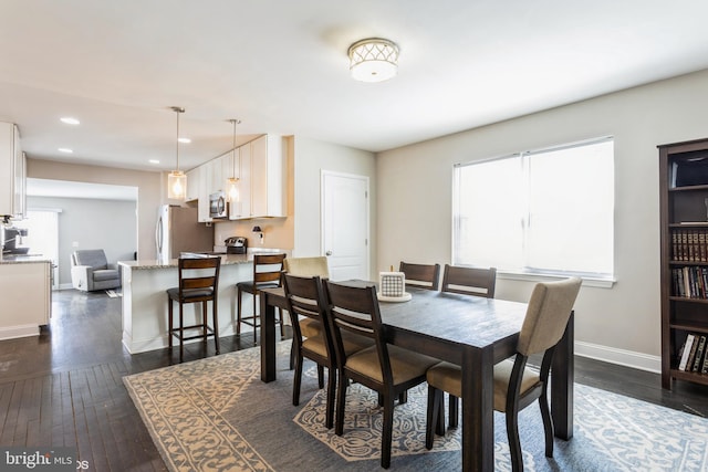 dining space with baseboards, dark wood-type flooring, and recessed lighting