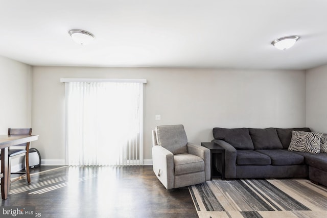 living area featuring dark wood-style flooring and baseboards