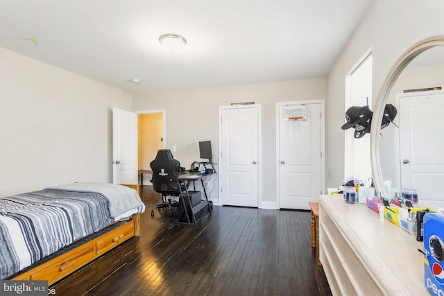 bedroom with dark wood-type flooring and baseboards