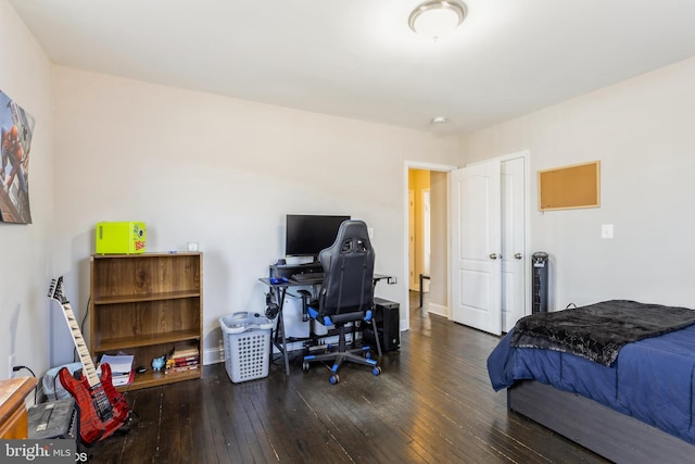 bedroom with wood-type flooring and baseboards