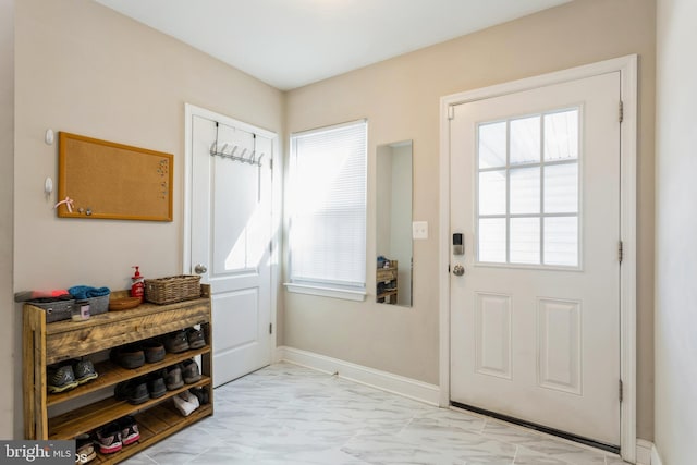 doorway featuring marble finish floor and baseboards