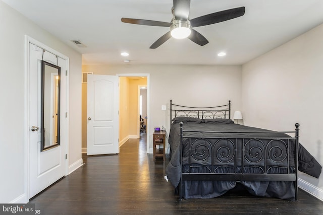 bedroom with baseboards, visible vents, and wood finished floors