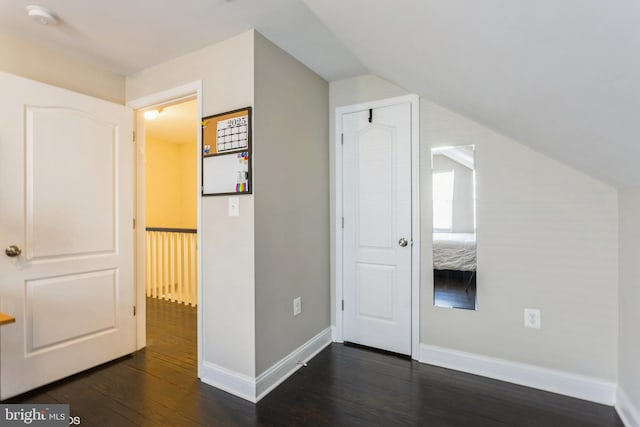 bonus room with vaulted ceiling, dark wood finished floors, and baseboards