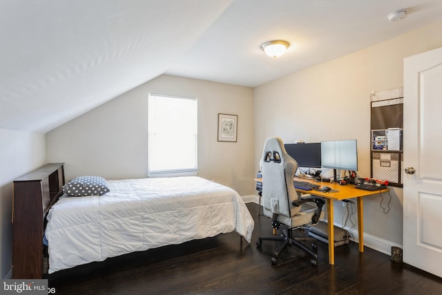 bedroom with lofted ceiling, hardwood / wood-style flooring, and baseboards