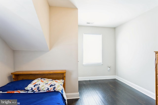 unfurnished bedroom featuring baseboards, visible vents, and hardwood / wood-style floors