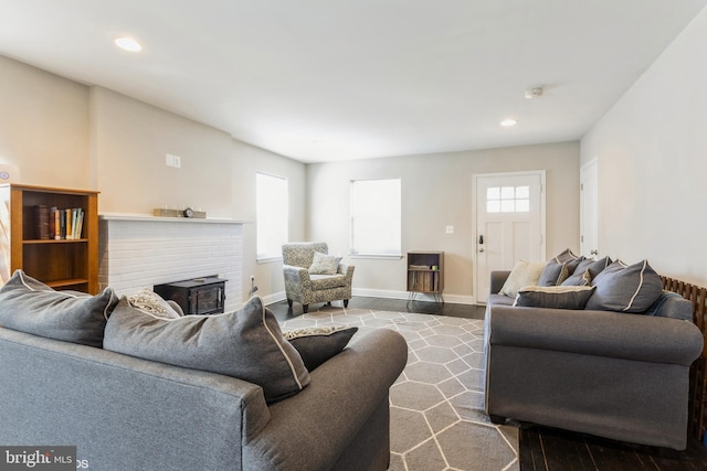 living area featuring recessed lighting, a fireplace, wood finished floors, and baseboards