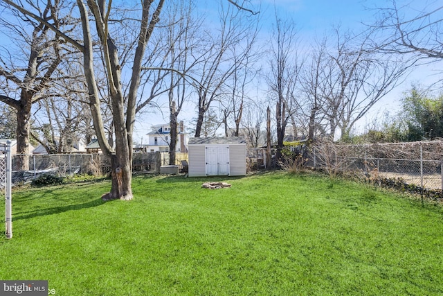 view of yard with a storage shed, an outdoor structure, and a fenced backyard