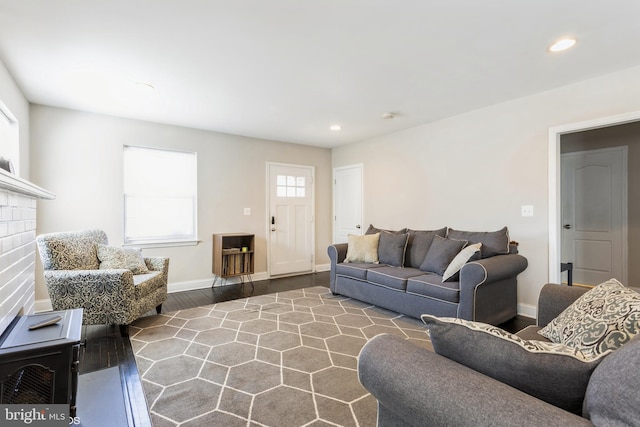 living area with baseboards, a brick fireplace, wood finished floors, and recessed lighting