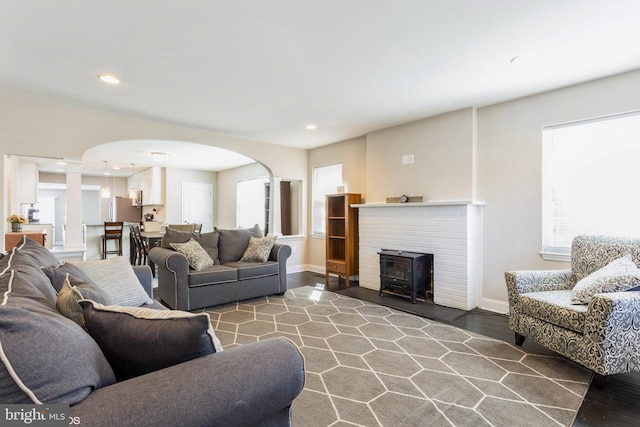 living area with recessed lighting, decorative columns, arched walkways, and baseboards