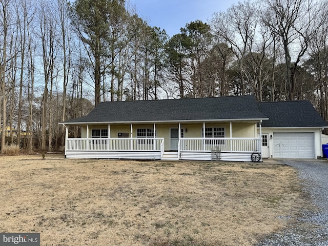 single story home with covered porch, a shingled roof, gravel driveway, and a garage